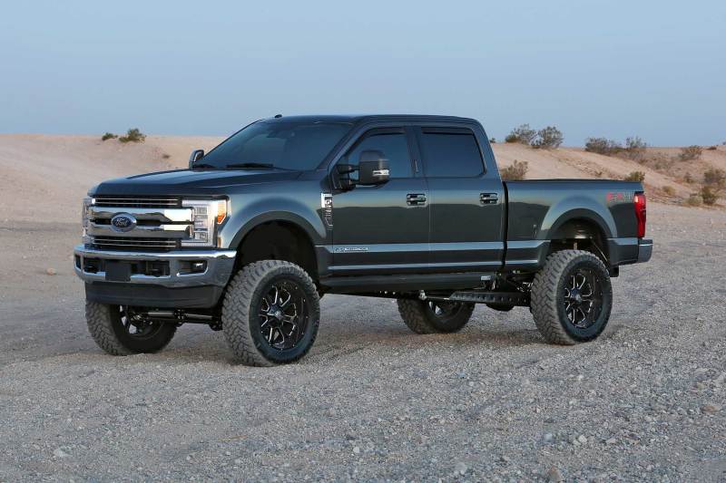 Lifted Ford Super Duty truck with off-road wheels parked in the desert